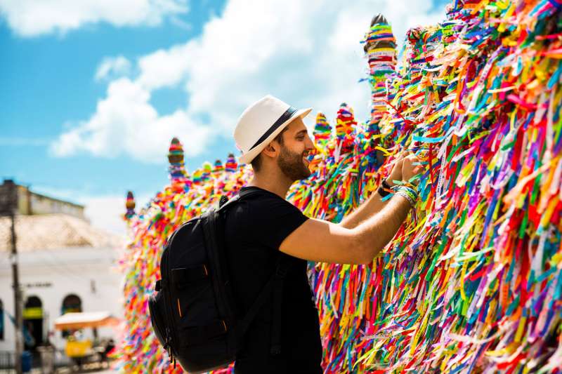 Man tying a ribbon to a fence