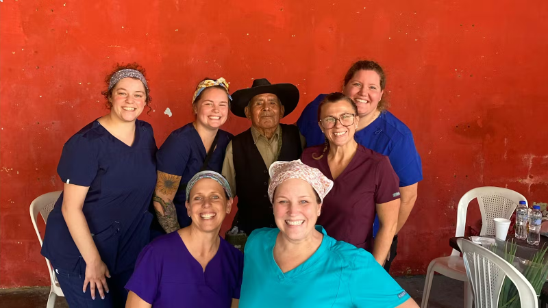 Medical Campaign Volunteers taking a photo with a Senior Local