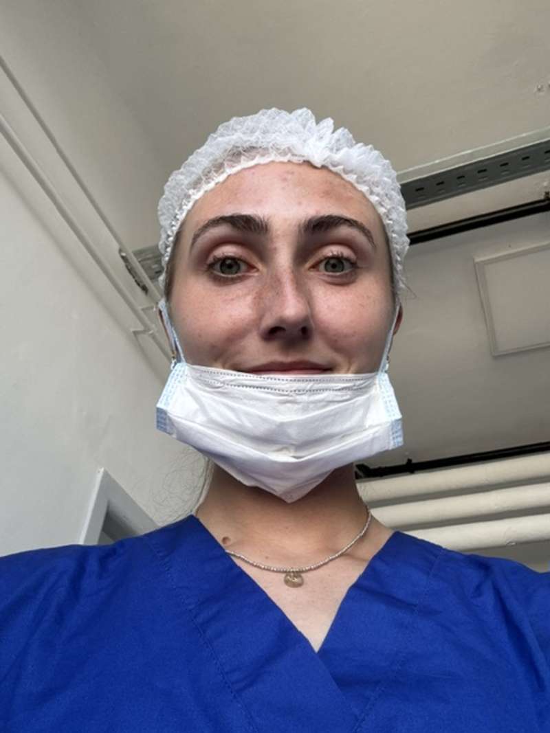Medical intern in Uruguay taking notes while observing a doctor during patient rounds in a hospital setting