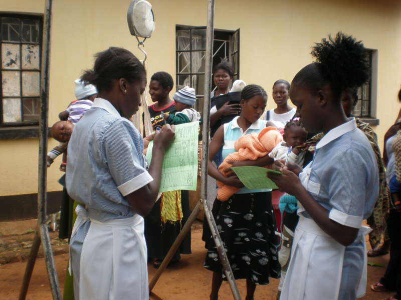 Nurses writing down weights of the babies