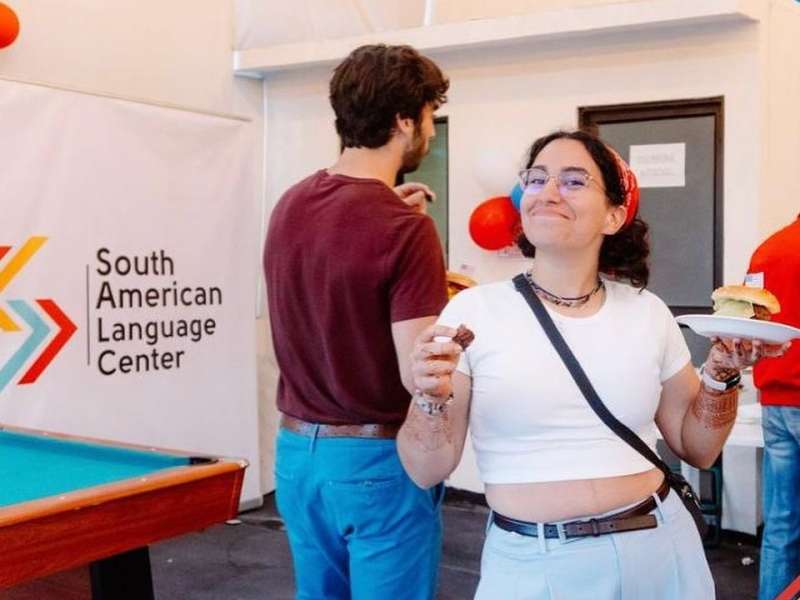 One of our interns posing in front of a South American Language Center banner in Ecuador!