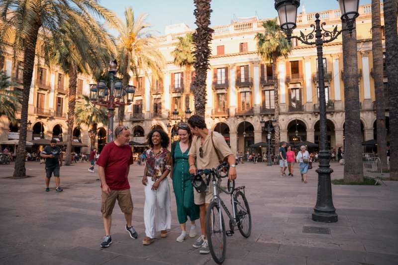people in barcelona walking with bike