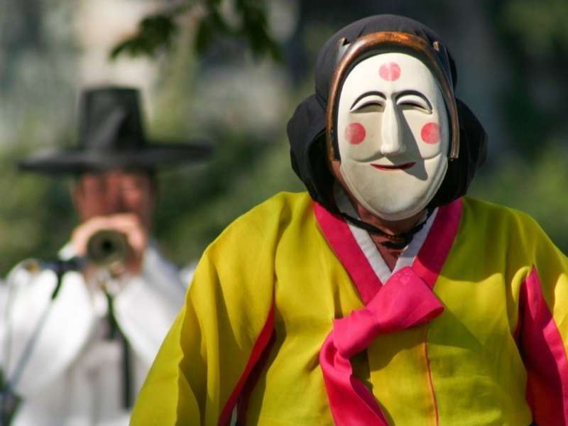 Person wearing traditional South Korean mask