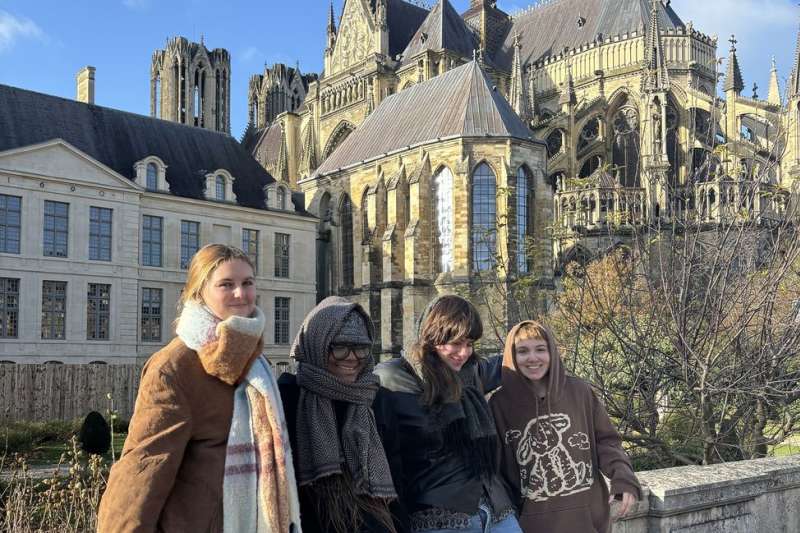 Program participants smiling beside French cathedral