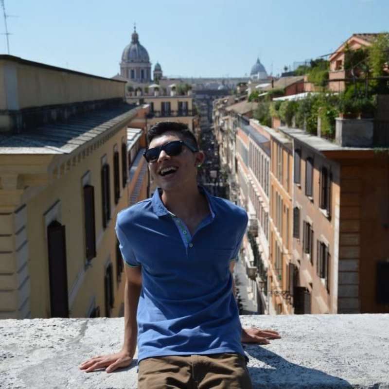 intern posing with the city of Rome as background