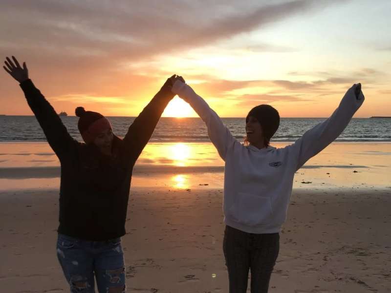 RVF teachers celebrating a sunset on a Spanish beach, full of joy.