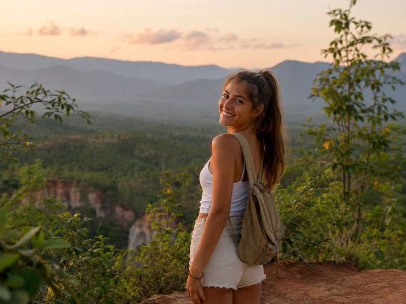 Solo traveller overlooking mountains in northern Thailand at sunset