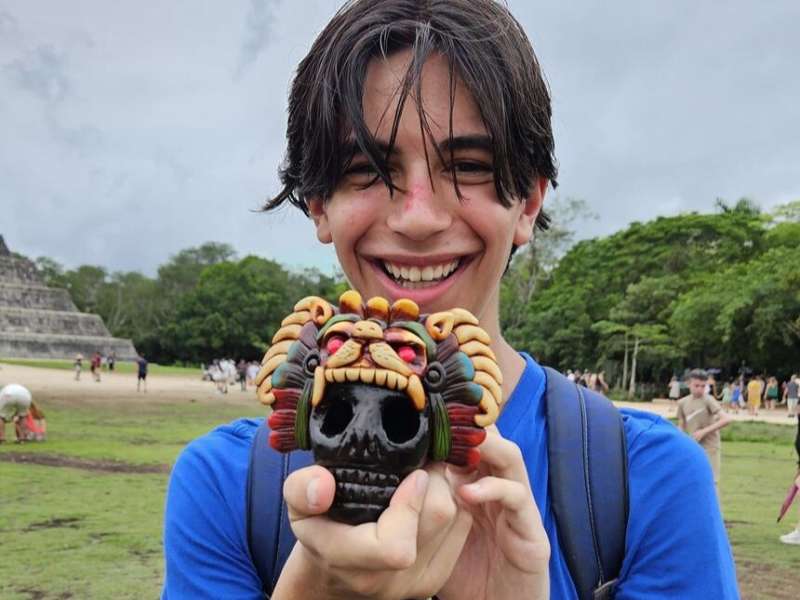 Student holding up Dia de los Muertos head in Merida
