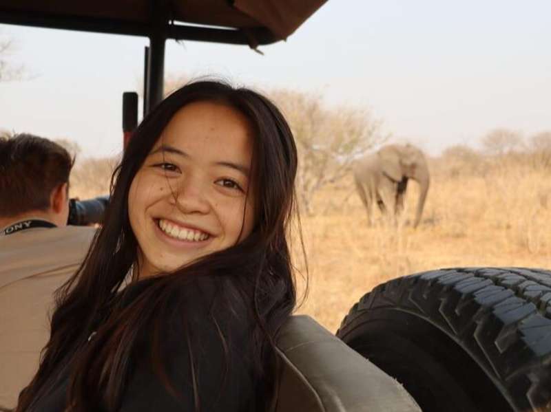 Student in Gaborone on safari with elephant in the background