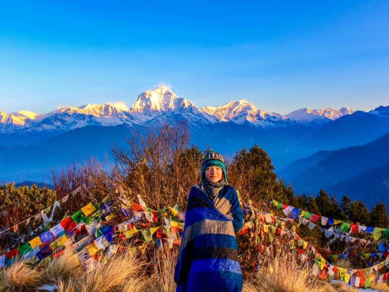 Student on top of mountain with prayer flags