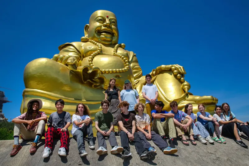 Student pose in front of giant buddha 