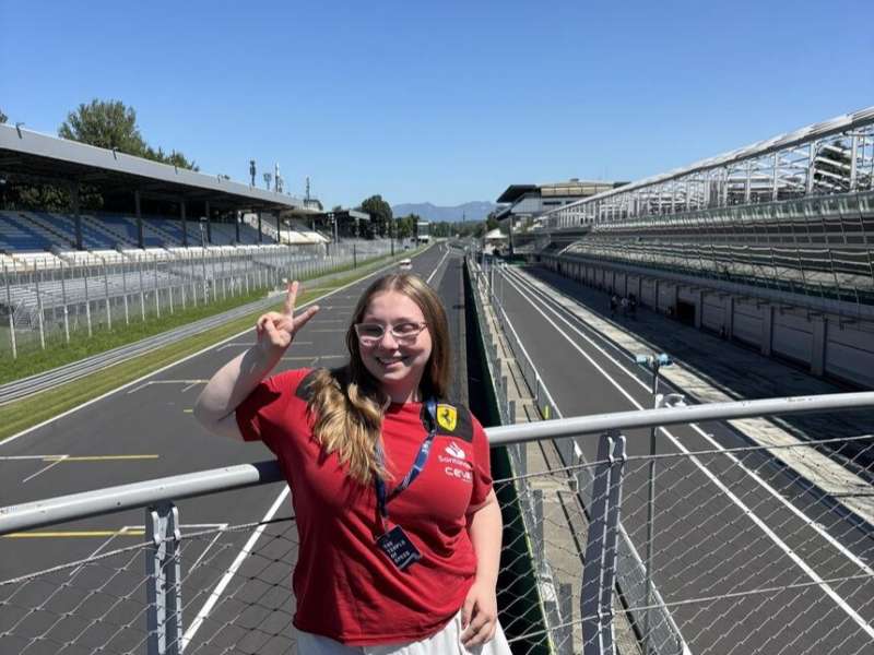 Student posing in front of race track in Italy