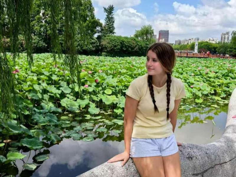 Student posing near lily pond in Shanghai