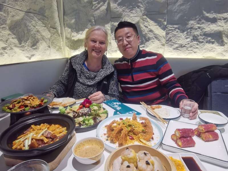 Student sharing a meal with her teacher in Dalian