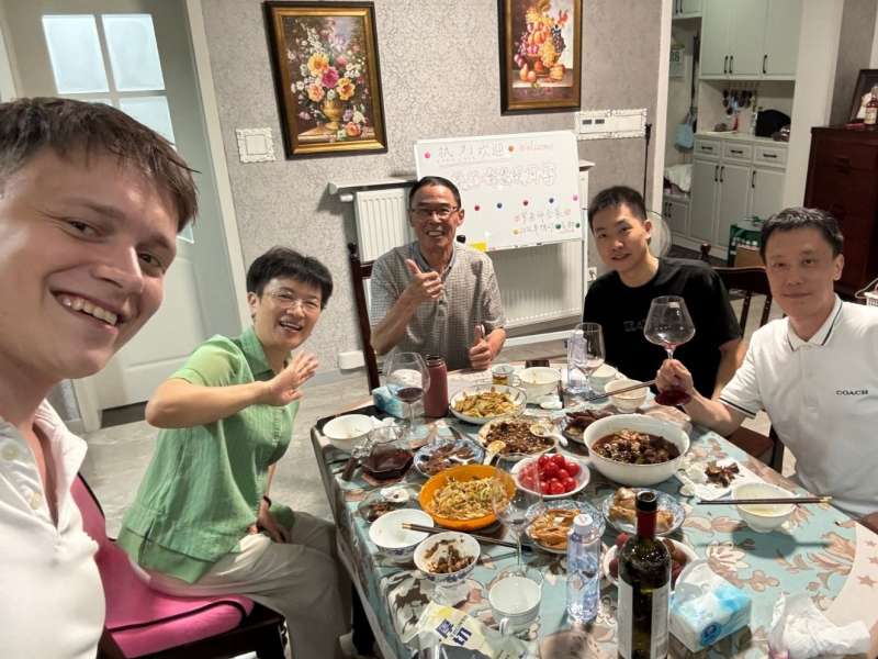 Student sharing a meal with his teacher and family