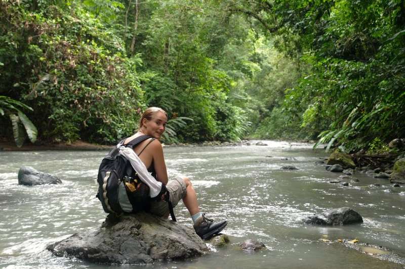 Student sitting on a rock on a hike in Monteverde