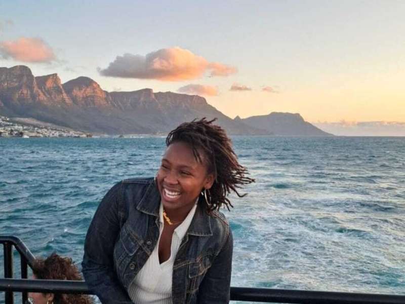 Student smiles on boat overlooking mountain in Cape
Town