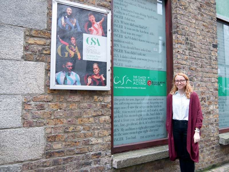 Student standing in front of Gaiety School of Acting sign on building exterior