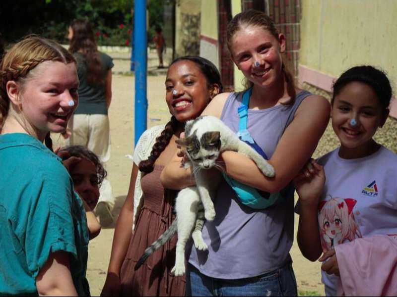 Students and kids holding cats in Morocco