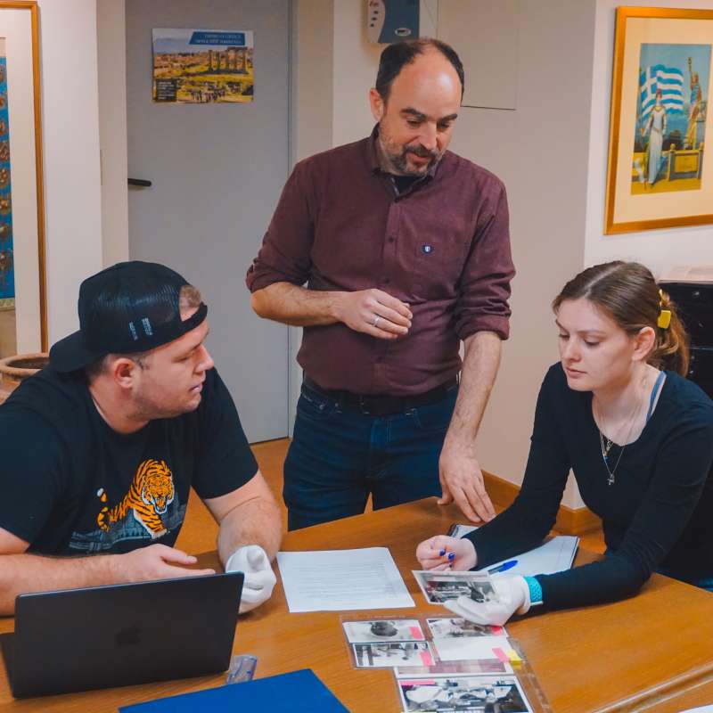 Students and professor looking at archived photos