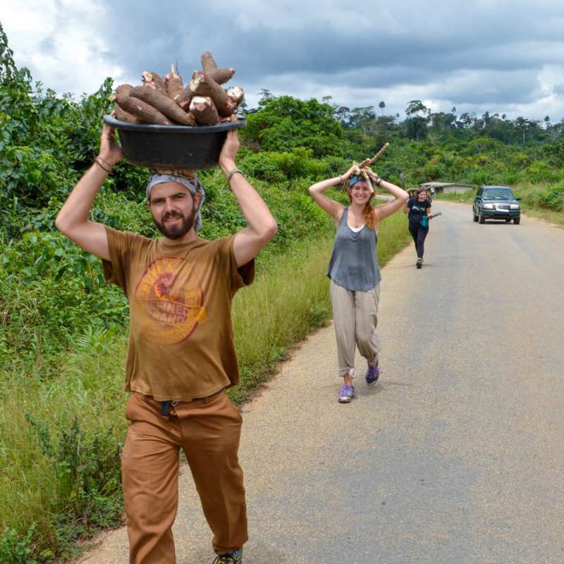 Students carrying supplies on their heads on a road in Ghana.