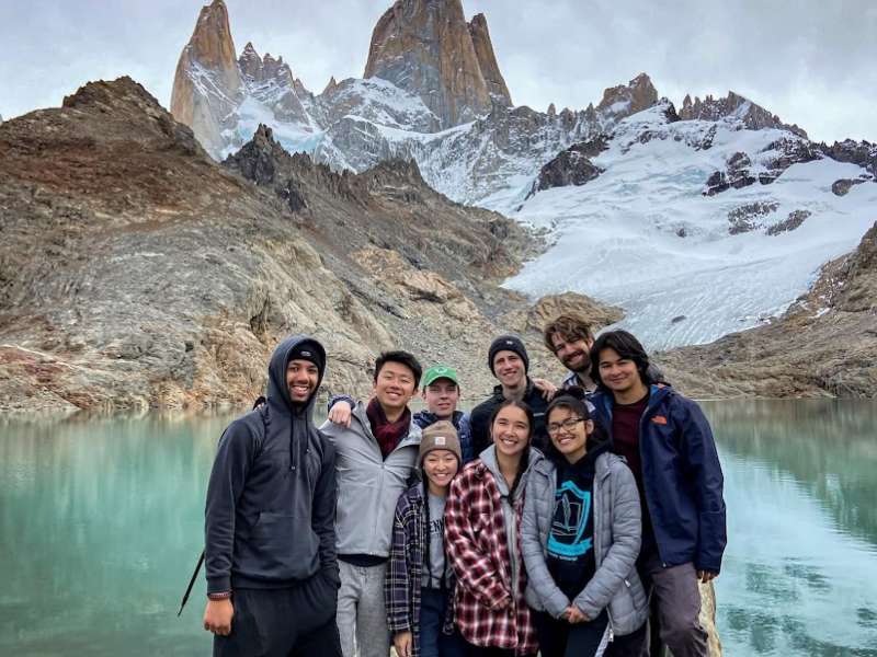 students in front of a lagoon and mountains in Argentine Patagonia.