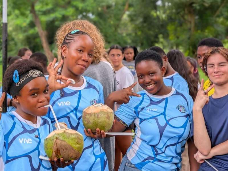 Students in jerseys with coconut water in Legon