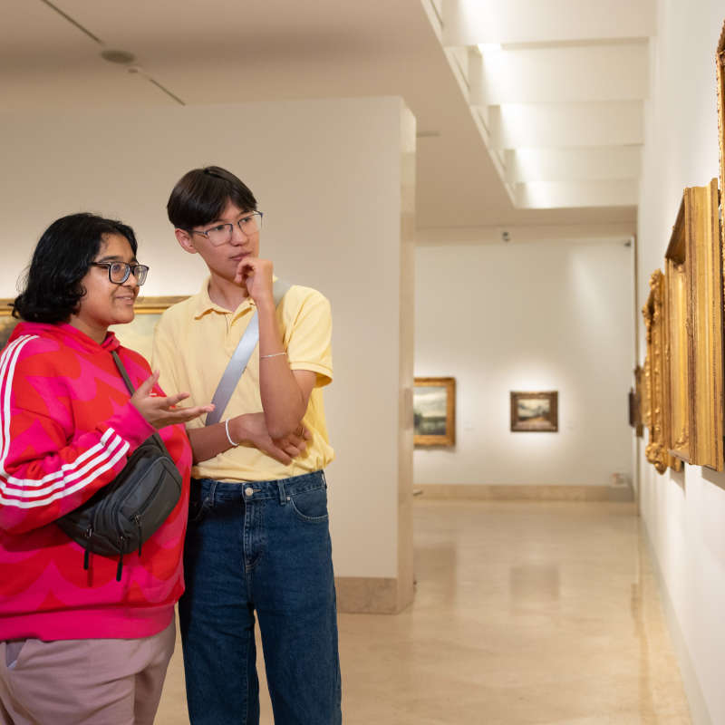 Students look at artwork at a museum.
