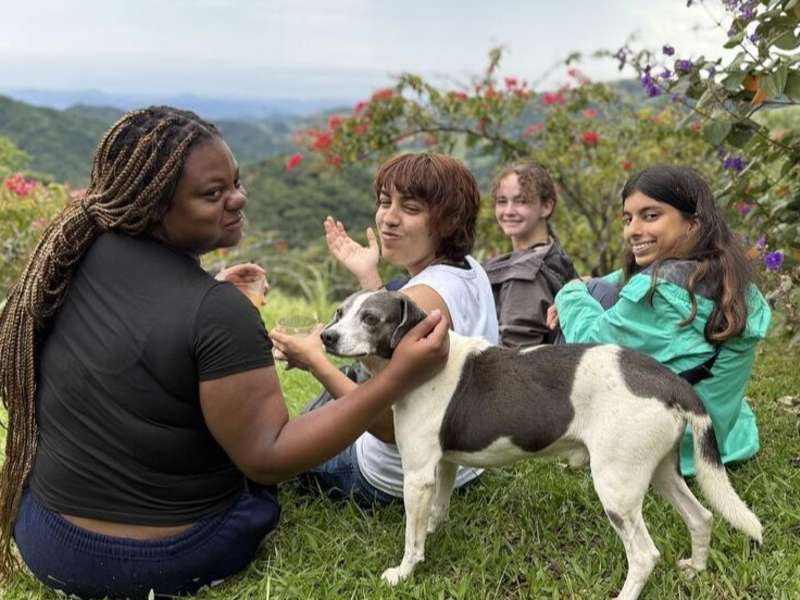 Students petting dog on overlook in Monteverde