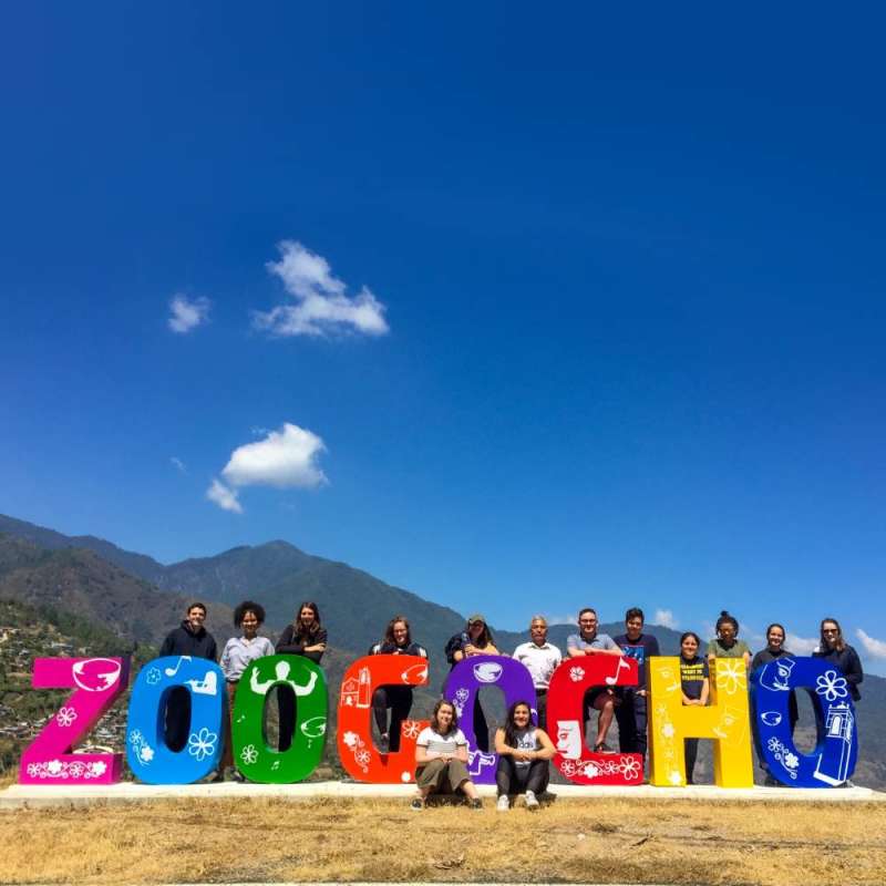 Students pose at Zoogocho sign.