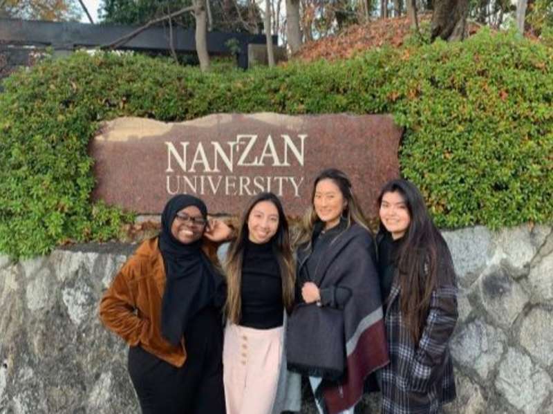 Students pose for a photo in front of the Nanzan University sign in Nagoya.