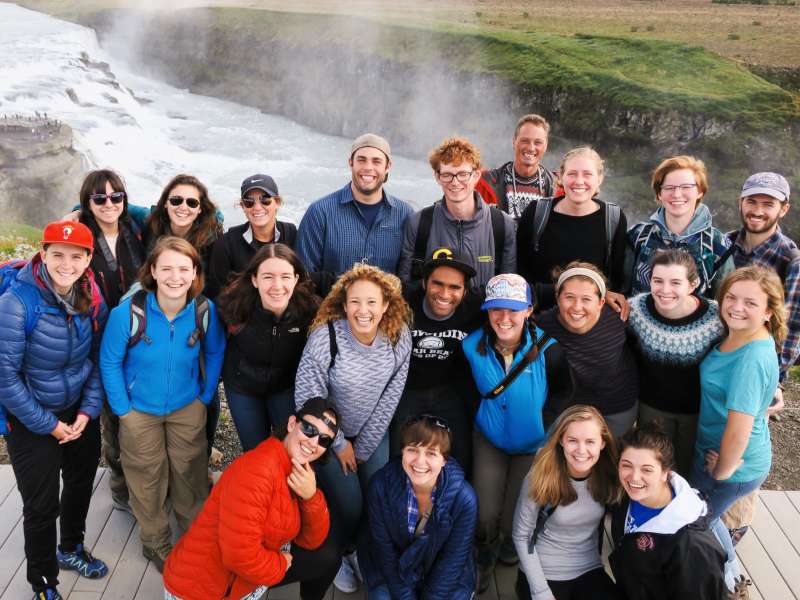 Students pose in front of waterfall