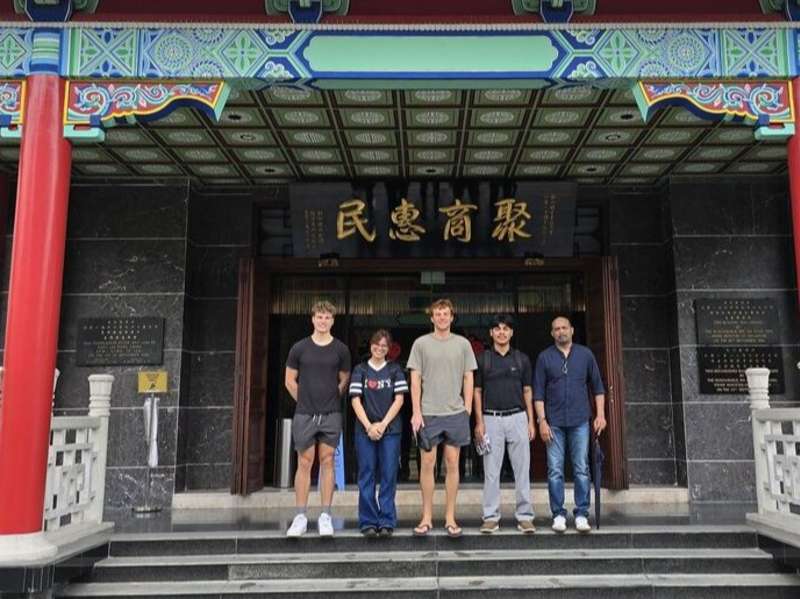 Students posing in front of Chinese commerce building