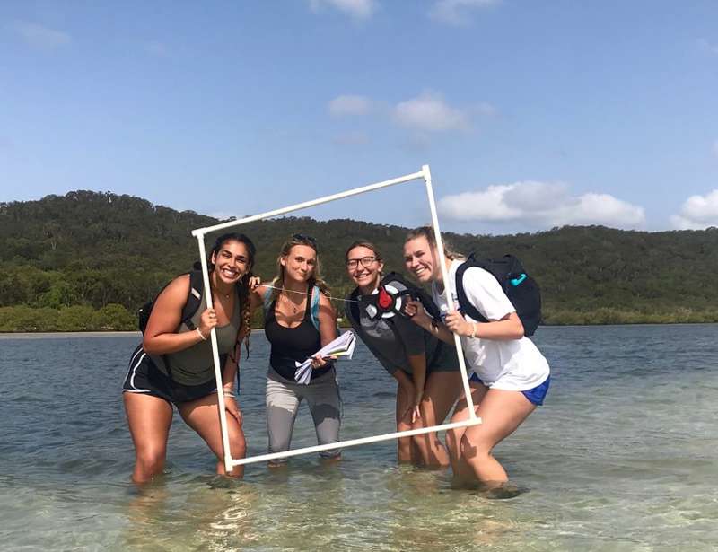 Students posing in shallow water.