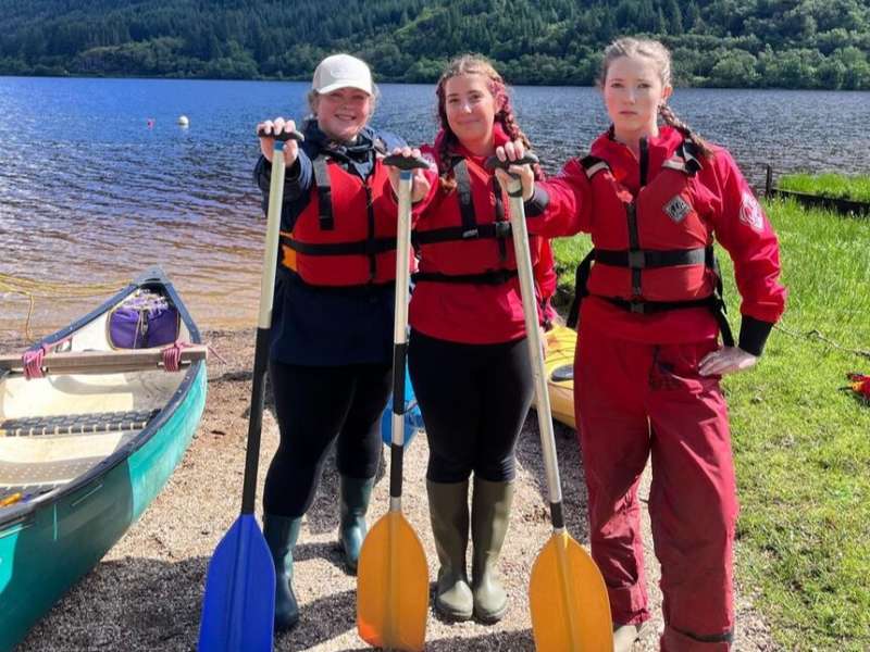 Students posing with kayaks in Scotland