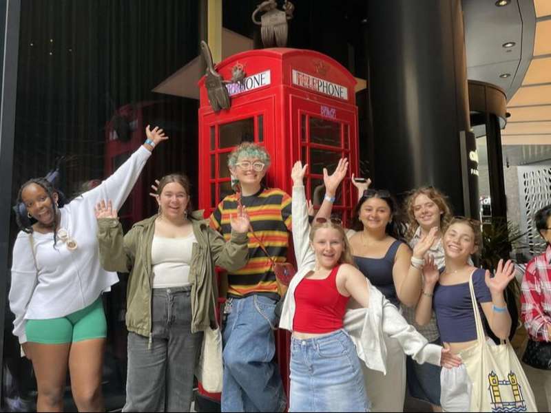 Students posing with phone booth in London