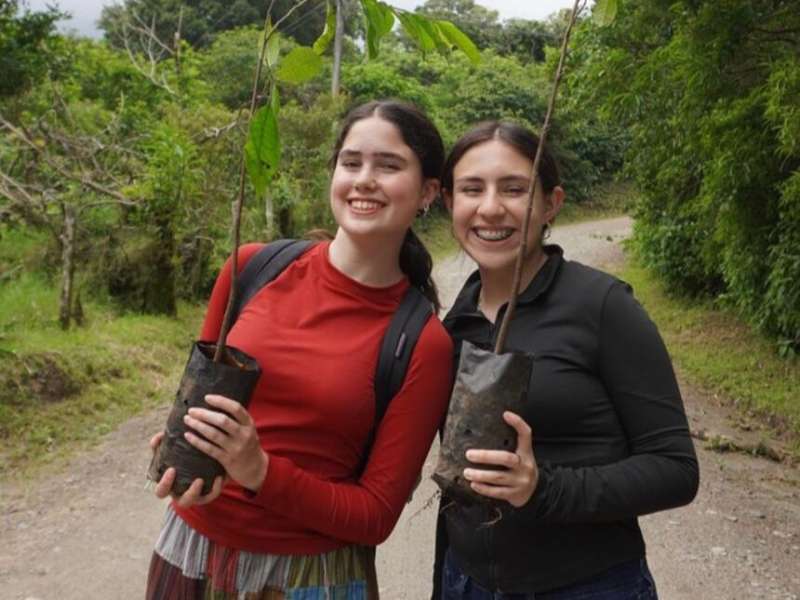 Students posing with trees for planting in Monteverde