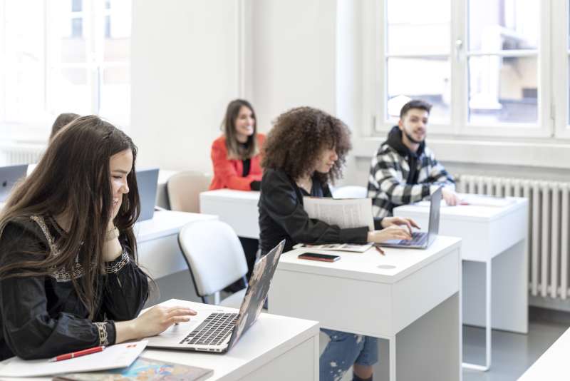 students sat at desks with laptops