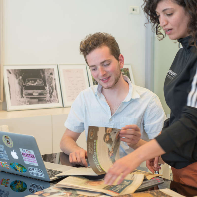 Students sit at a laptop.