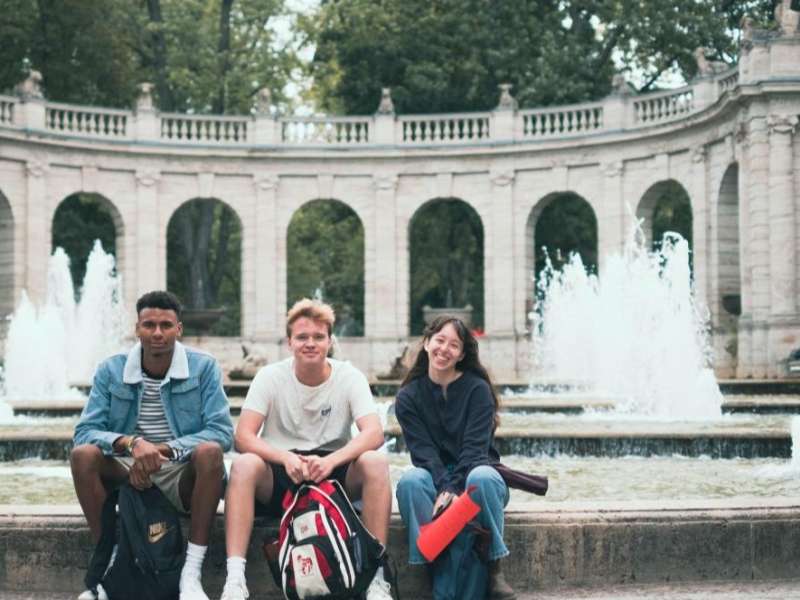 Students sit by a fountain in between classes in Berlin, Germany.
