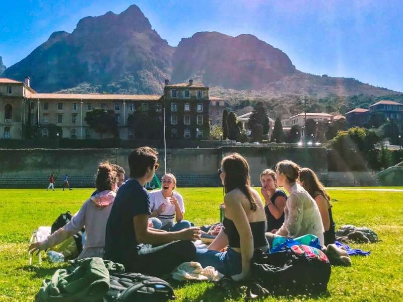 Students sit in lawn with Lion's Head in the background