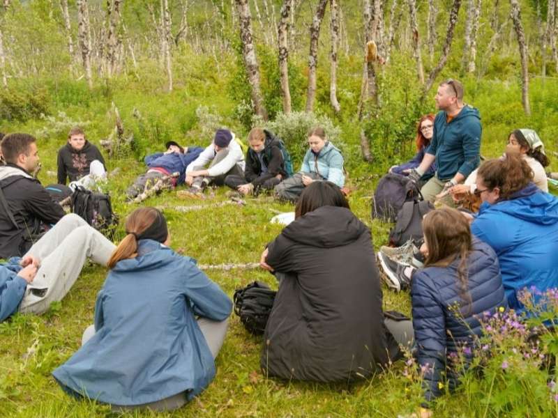 Students sitting in a circle in the forest