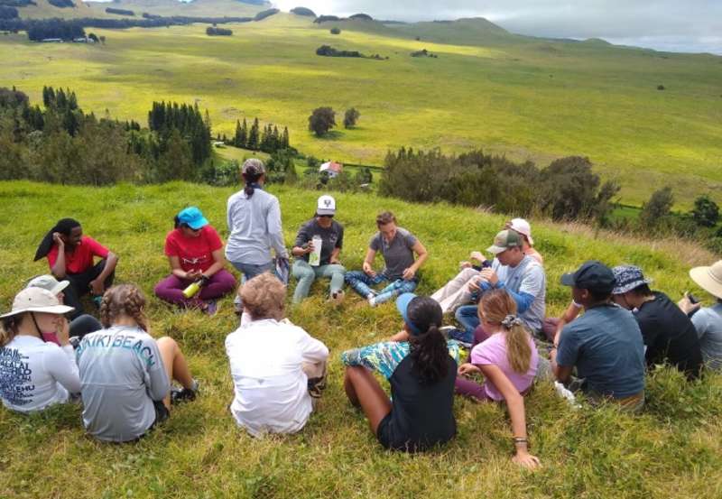 students sitting in circle in hawaii