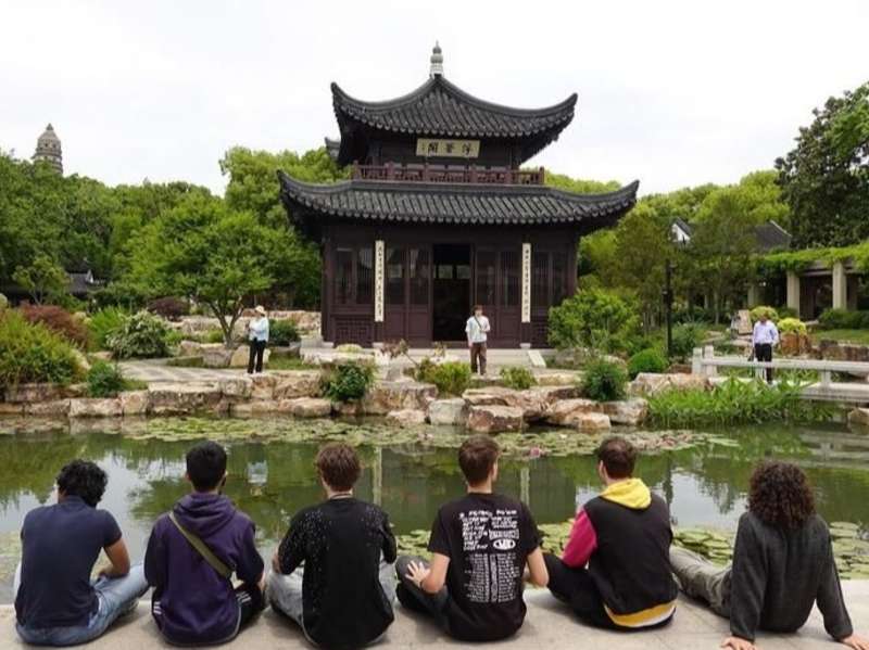 Students sitting in front of temple in China