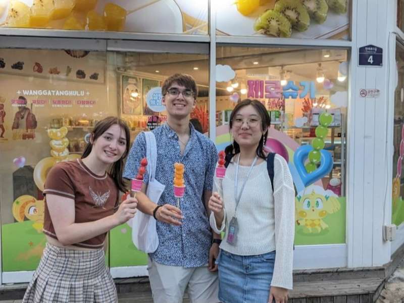 Students smiling and eating ice cream in Seoul.