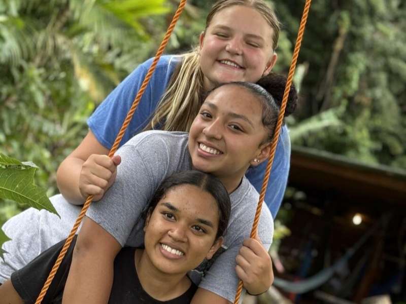 Students smiling in swing on program in Monteverde