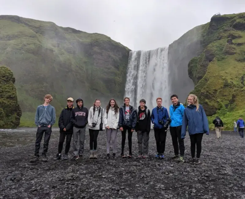 Students stand in front of waterfall