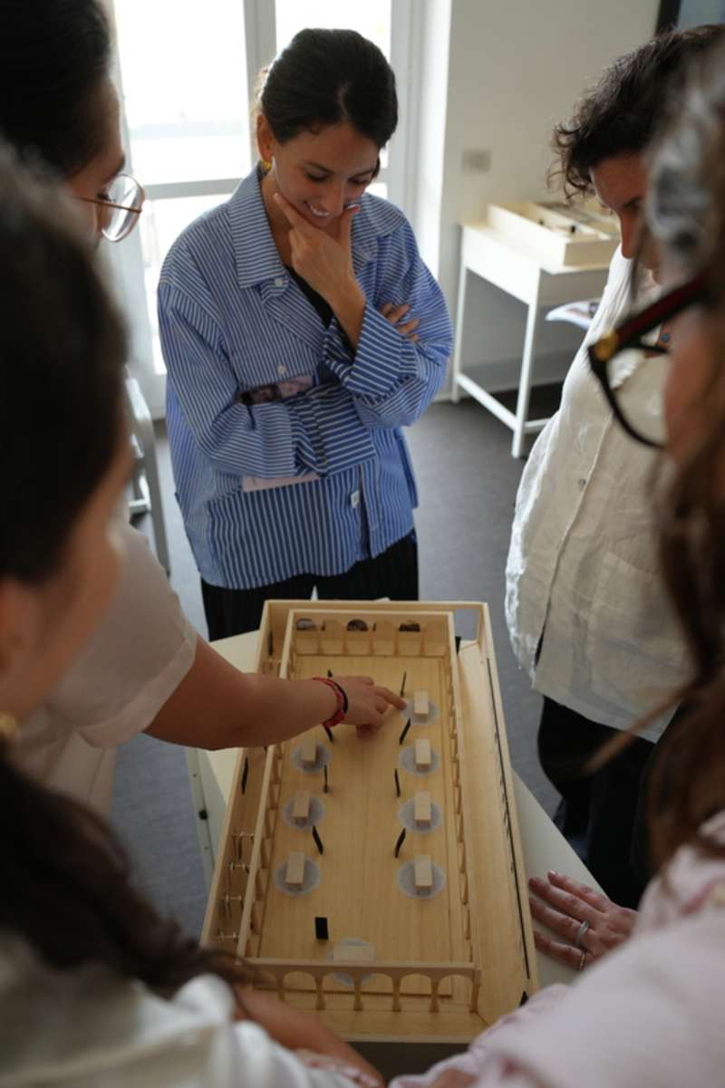 Students standing round an interior design model