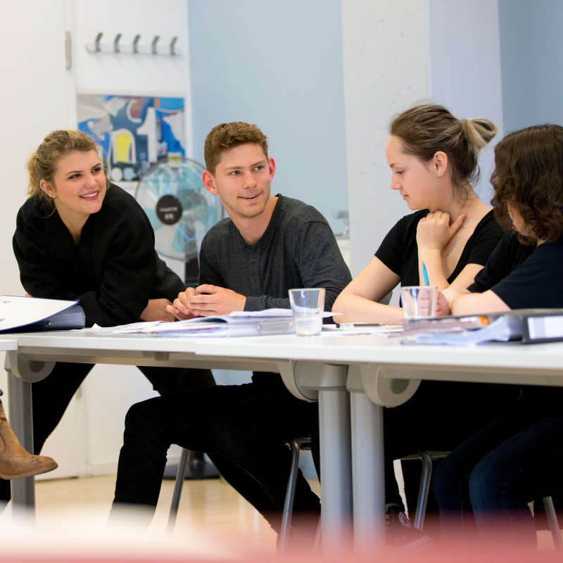 Students talking in a classroom.