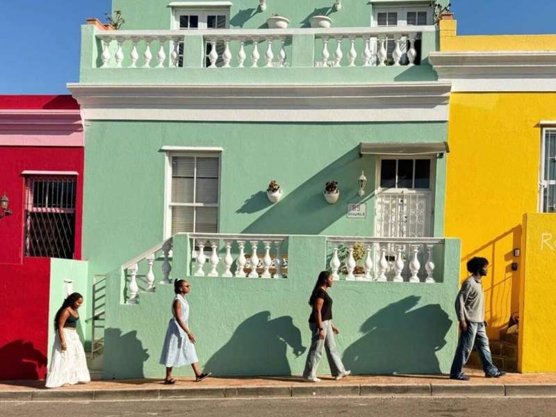 Students walk against colorful buildings in Bo-Kaap Cape Town